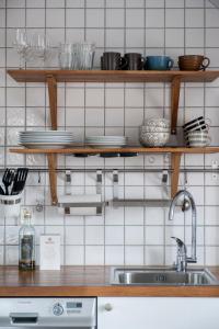 a kitchen with wooden shelves and a sink at Sköna Hönor Apartments in Visby