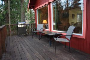 taras ze stołem i krzesłami na domu w obiekcie Mt Rainier Little Red Cabin w mieście Ashford