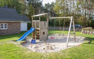 a playground with a slide and a swing at Ausguck - Hüs in Lee in Süddorf