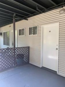 a garage with a white door on a house at Roey Backpackers and Party Bar in Broome