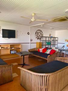 a living room with couches and a flat screen tv at Roey Backpackers and Party Bar in Broome
