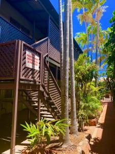 a resort with palm trees and a staircase with a sign at Roebuck Bay Backpackers in Broome +29 photos