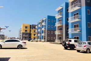 ein Parkplatz mit Autos, die vor Gebäuden geparkt sind in der Unterkunft Luxury Tema community 25 gated1-bedroom apartment - Fivehills homes in Tema