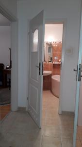 Cette chambre dispose d'une porte et d'une salle de bains pourvue d'une baignoire. dans l'établissement miły pokój niedaleko centrum i starego miasta, à Varsovie