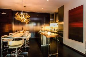a kitchen with a bar with chairs and a chandelier at Dream Penthouse at Palms Place in Las Vegas