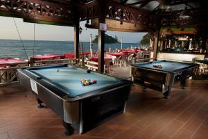 two pool tables in a bar with tables and chairs at Paya Beach Spa & Dive Resort in Tioman Island