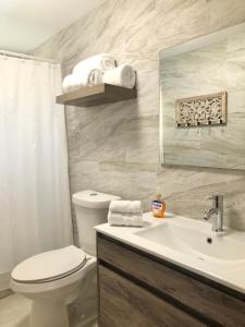 a bathroom with a white toilet and a sink at The Beach Guesthouse in Pinones