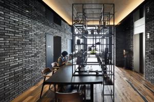a dining room with a table and a brick wall at Hotel Resol Akihabara in Tokyo