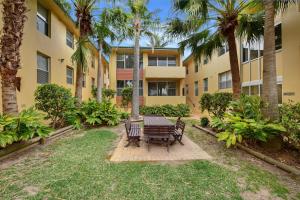 a patio with a table and chairs in front of a building at Oxley Cove Holiday Apartment in Port Macquarie