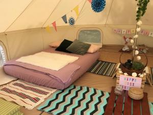 Glamping Kaki - Medium Bell Tent في سنغافورة: غرفة نوم بسرير في خيمة