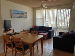 a living room with a table and a couch at Oxley Cove Holiday Apartment in Port Macquarie