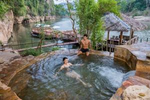 two men in a plunge pool in a river at Hintok River Camp - SHA Extra Plus in Sai Yok