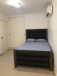 Un pat sau paturi într-o cameră la Linda casa 12 Malecon Central Park Acuario