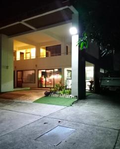 a building at night with a lawn in front of it at Nontharat Mansion in Nonthaburi