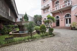 a courtyard with a fountain in a pink building at RedDoorz @ Lawang in Malang