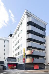 a white building with balconies on the side of it at Namba Ebisu Hotel in Osaka