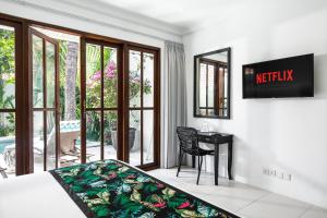 a bedroom with a bed and a desk with a sign on the wall at Villa Merah in Seminyak