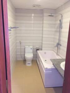 a bathroom with a tub and a toilet and a sink at Binh Minh Dien Chau Hotel in Diễn Châu