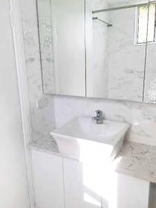 a white bathroom with a sink and a mirror at 1 Private Double Room In Carramar 1-minute to Station - ROOM ONLY in Sydney