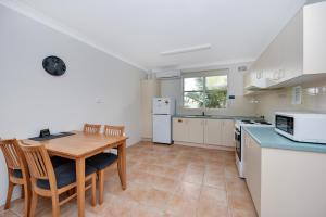 een keuken en eetkamer met een tafel en stoelen bij Oxley Cove Holiday Apartment in Port Macquarie