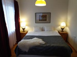 a bedroom with a white bed with two lamps at White Villa in Tallinn