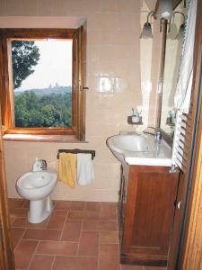 a bathroom with a sink and a toilet and a window at Podere Le Grotte in San Gimignano