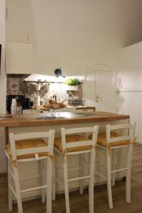 cocina con mesa, 2 sillas y lavamanos en Alle Volte ..., en Matera