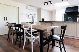 uma cozinha e sala de jantar com uma mesa de madeira e cadeiras em Nest House Bright em Bright