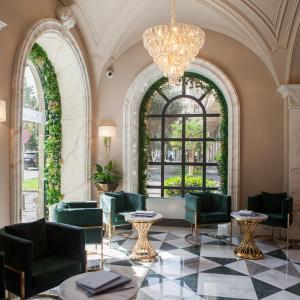 a lobby with chairs and tables and a chandelier at Promenade Hotel Baku in Baku