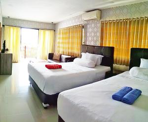 Habitación de hotel con 2 camas y sofá en Jos & Hanny Homestay en Batu