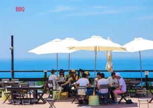 a group of people sitting at tables under umbrellas at Grampus Sea in Shirahama