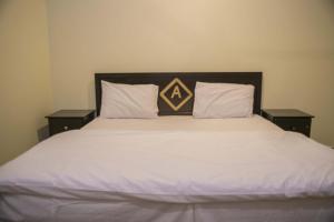 a large bed with two pillows on top of it at العييري للشقق المخدومة القصيم 4 in Buraydah