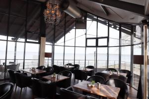 グライフスヴァルトにあるHotel & Restaurant Utkiekのテーブルと椅子、大きな窓のあるレストラン