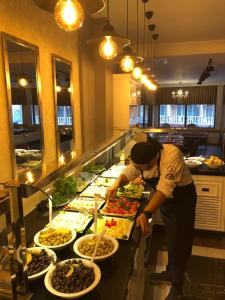 a man preparing food at a buffet in a restaurant at Thermal Saray Hotel & Spa Yalova in Gokcedere