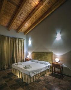 ドッソブオノにあるAgriturismo Le Case Di Campagnaのベッドルーム1室(ベッド1台、テーブル2台、ランプ2つ付)