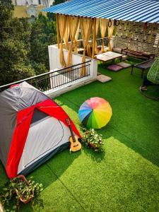 a tent and an umbrella on the grass at Moustache Delhi in New Delhi