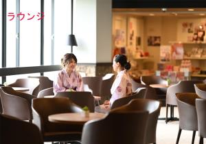 two women in kimonos sitting at tables in a restaurant at Grampus Sea in Shirahama