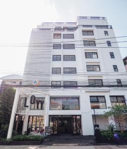 a tall white building with a sign on it at Loyy Hotel in Chiang Mai
