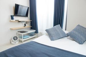 um quarto com uma cama, uma televisão e almofadas em Cozy Vibes Apt Hotel em Tóquio