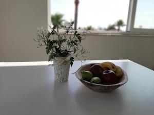 uma taça de fruta sentada numa mesa com um vaso em Limassol sea view studio em Limassol