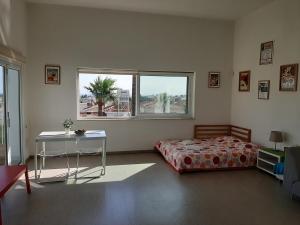 a bedroom with a bed and a table and windows at Limassol sea view studio in Limassol +4 photos