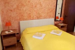 a yellow bed with two towels on top of it at Ca'Noa in Valstagna