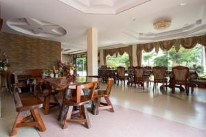 a dining room with wooden tables and chairs at The Star Hotel in Udon Thani