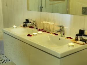 a white bathroom sink with candles and a mirror at Hondos Classic Hotel & Spa in Nestáni