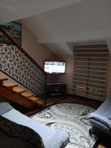 a living room with a staircase and a television at APARTMANI MIA VUKSANOVIC in Cetinje