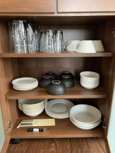 une armoire remplie de assiettes, de bols et de vaisselle dans l'établissement Big Stone Tsukuda 45平米 2SDbed 2For3F, à Aomori