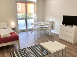 ルブリンにある#VisitLublin Apartments Premium Wschodniaのリビングルーム(ベッド1台、テーブル、テレビ付)