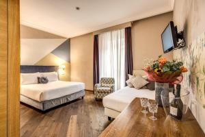 une chambre d'hôtel avec deux lits et une table dans l'établissement Boutique Hotel Galatea, à Rome