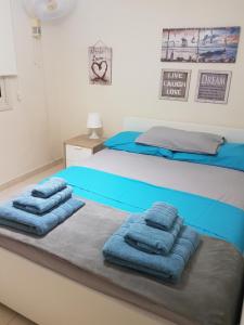 a bedroom with a bed with blue towels on it at Villa Venus in Perivolia