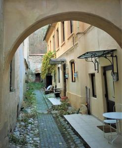 an archway in an alley between two buildings at White Wolf Apartment in Braşov